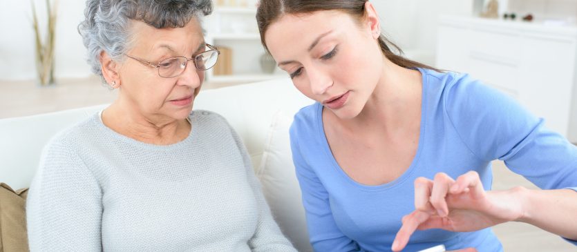 Young woman showing elderly woman how to use a tablet